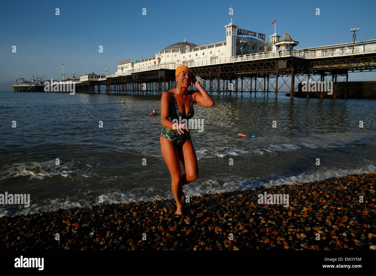 Un membro di Brighton Nuoto Club ottiene fuori del Mare dopo una nuotata mattutina al Molo di Brighton in East Sussex Regno Unito Foto Stock