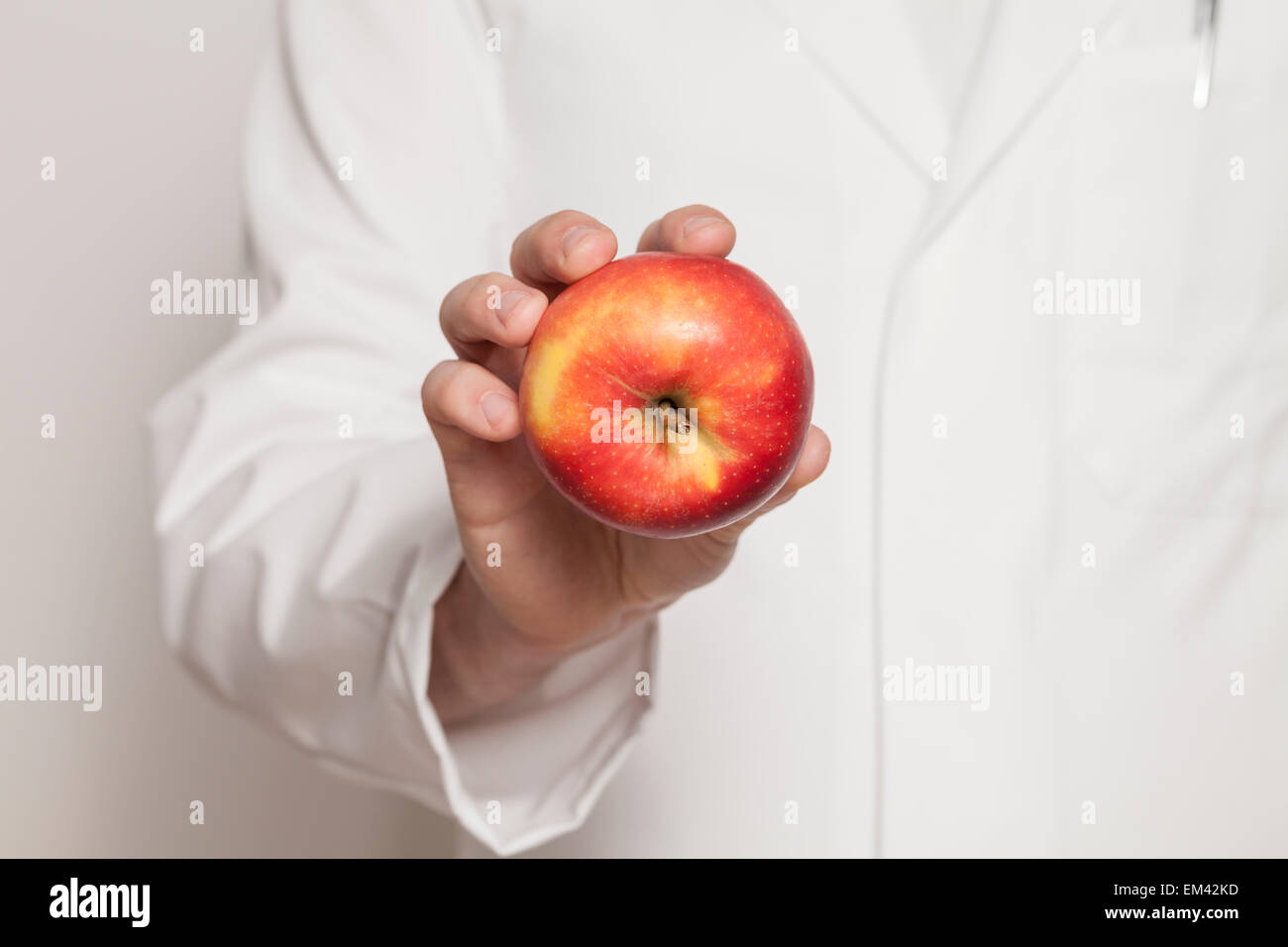 Medico tenendo una mela rossa in mano Foto Stock
