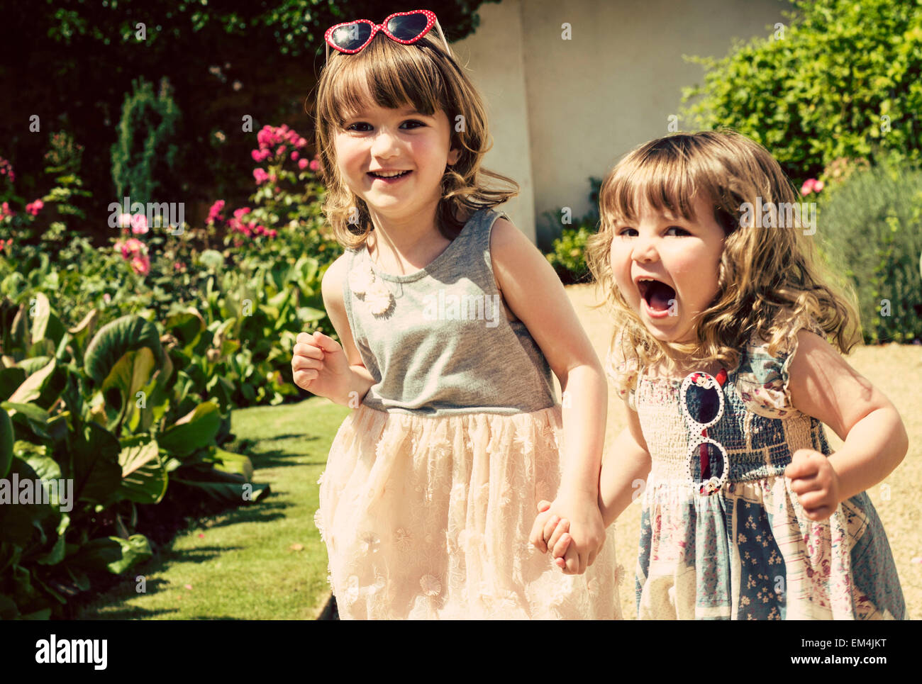 Due ragazze, figlia, luce verde, marrone capelli, sorridendo felice bokeh, faccia tirando, foresta , divertente, sconvolto, occhiali da sole, Foto Stock