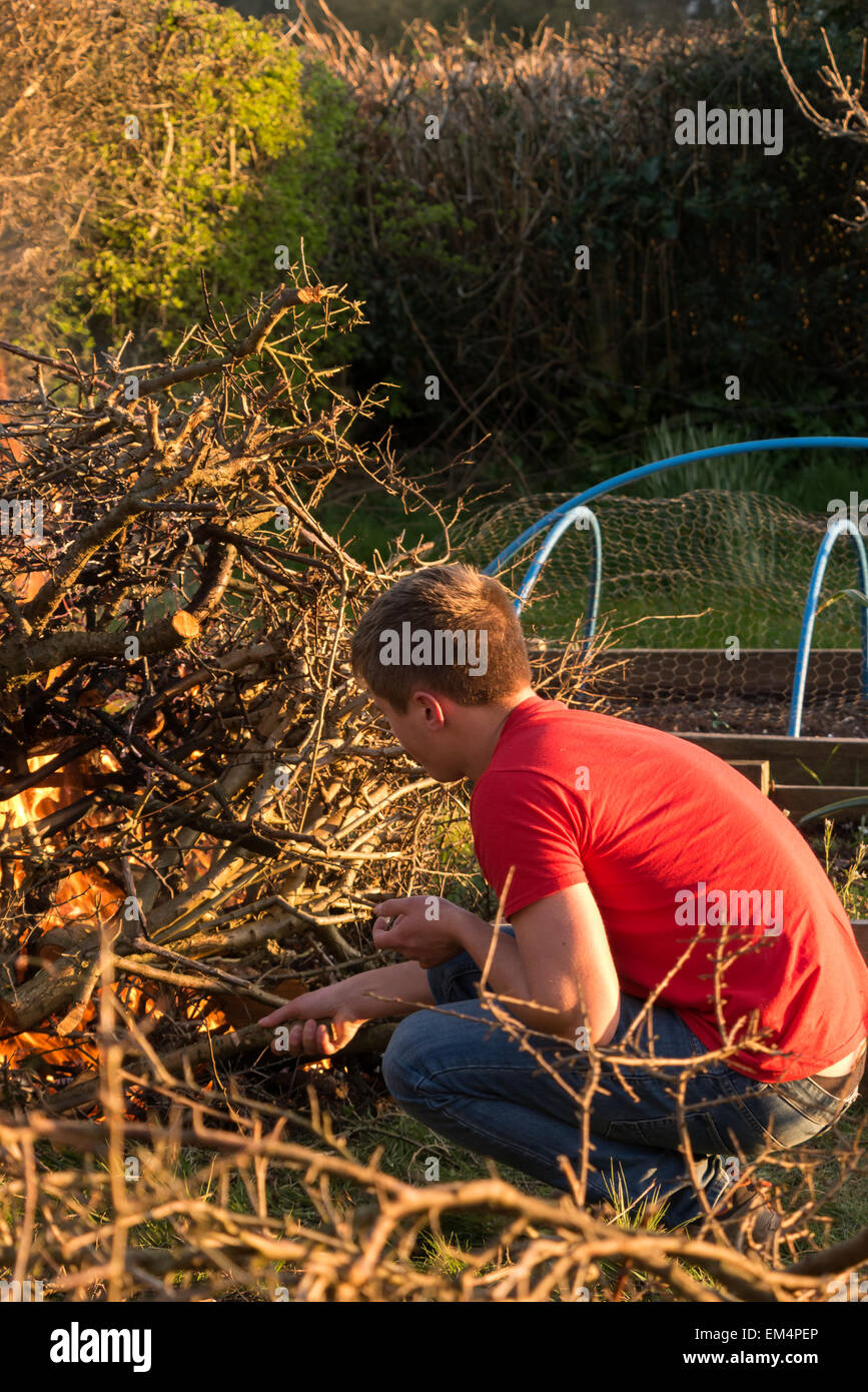 Illuminazione di un falò bruciando i rifiuti in giardino Foto Stock
