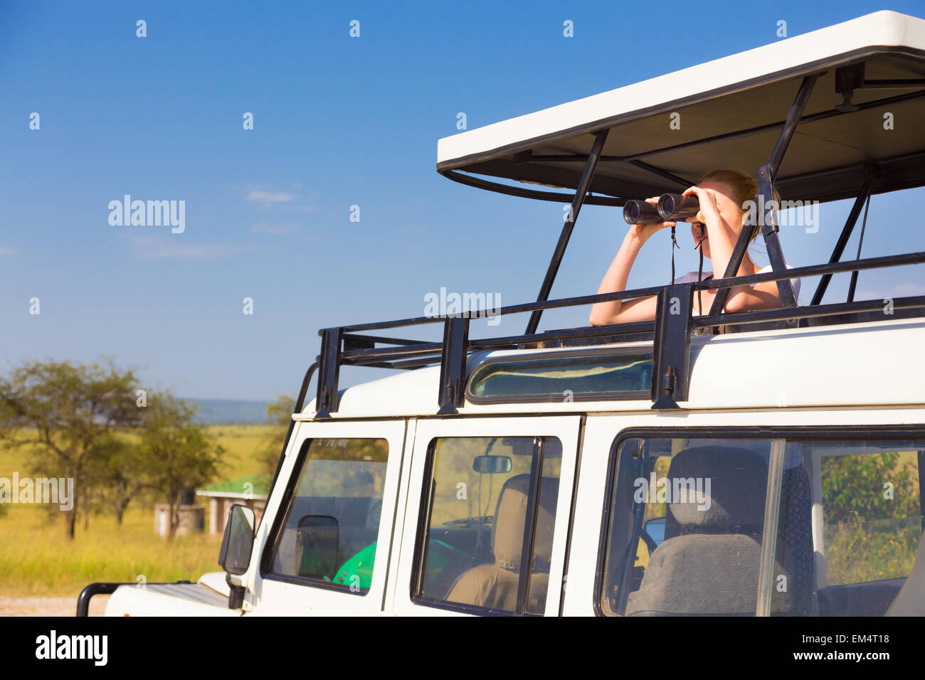 Donna su Safari cerca attraverso il binocolo. Foto Stock