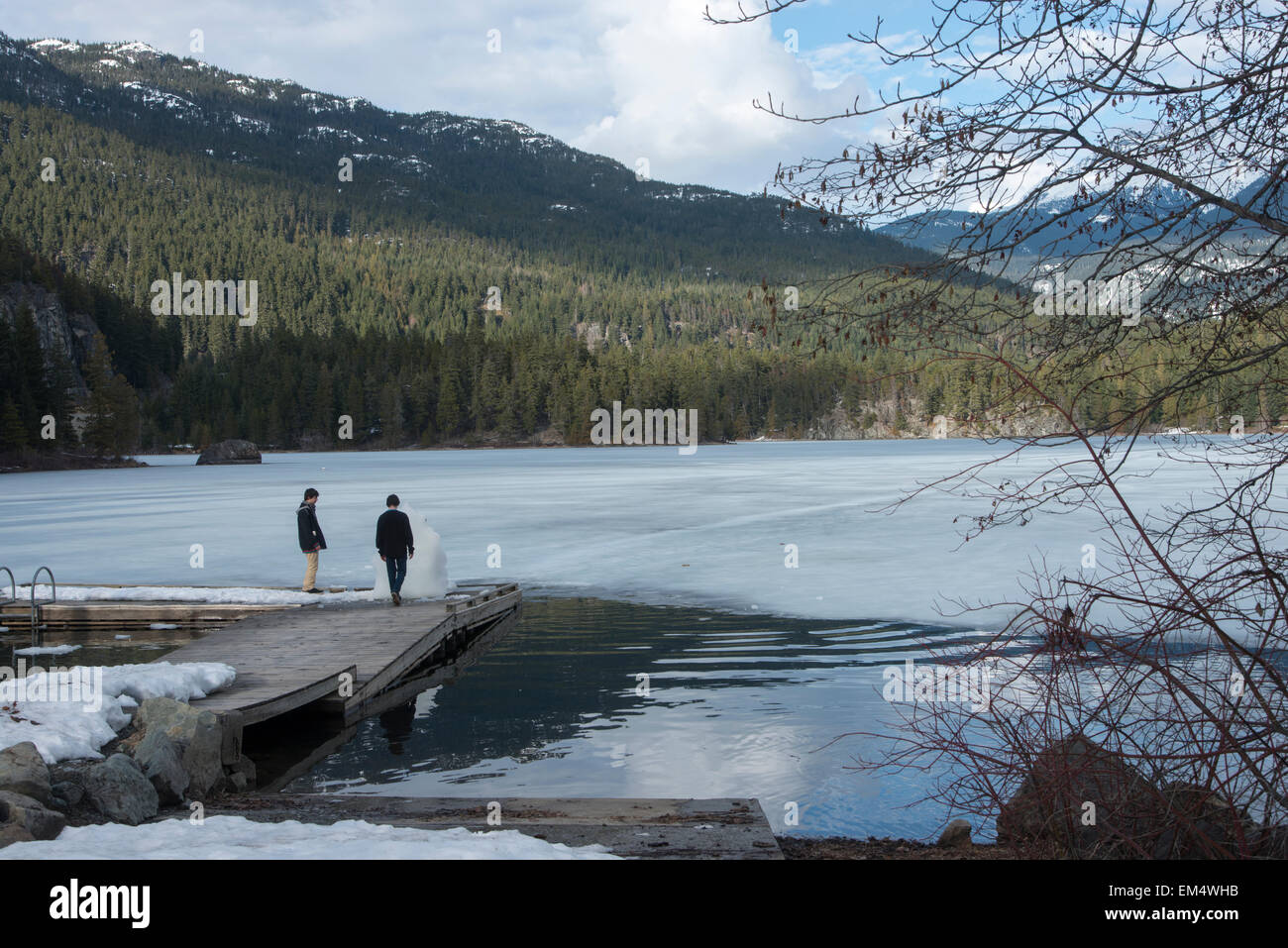 I turisti in piedi su un dock a lago, Whistler, British Columbia, Canada Foto Stock