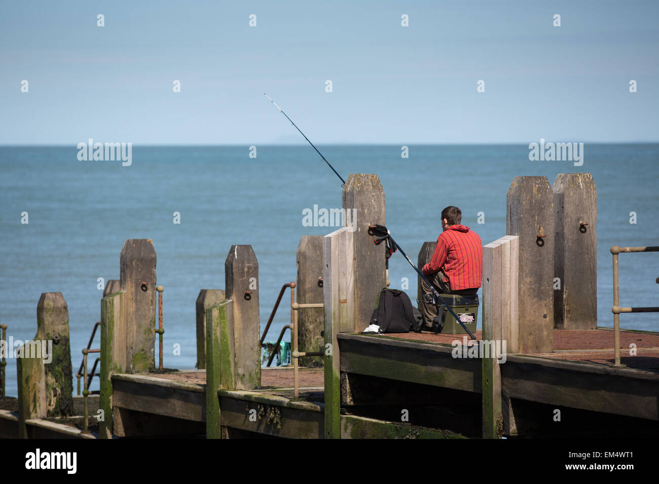 Aberystwyth, Wales, Regno Unito. Il 16 aprile 2015. Meteo. La pesca dal pontile in legno nel sole di primavera Credito: Alan Hale/Alamy Live News Foto Stock