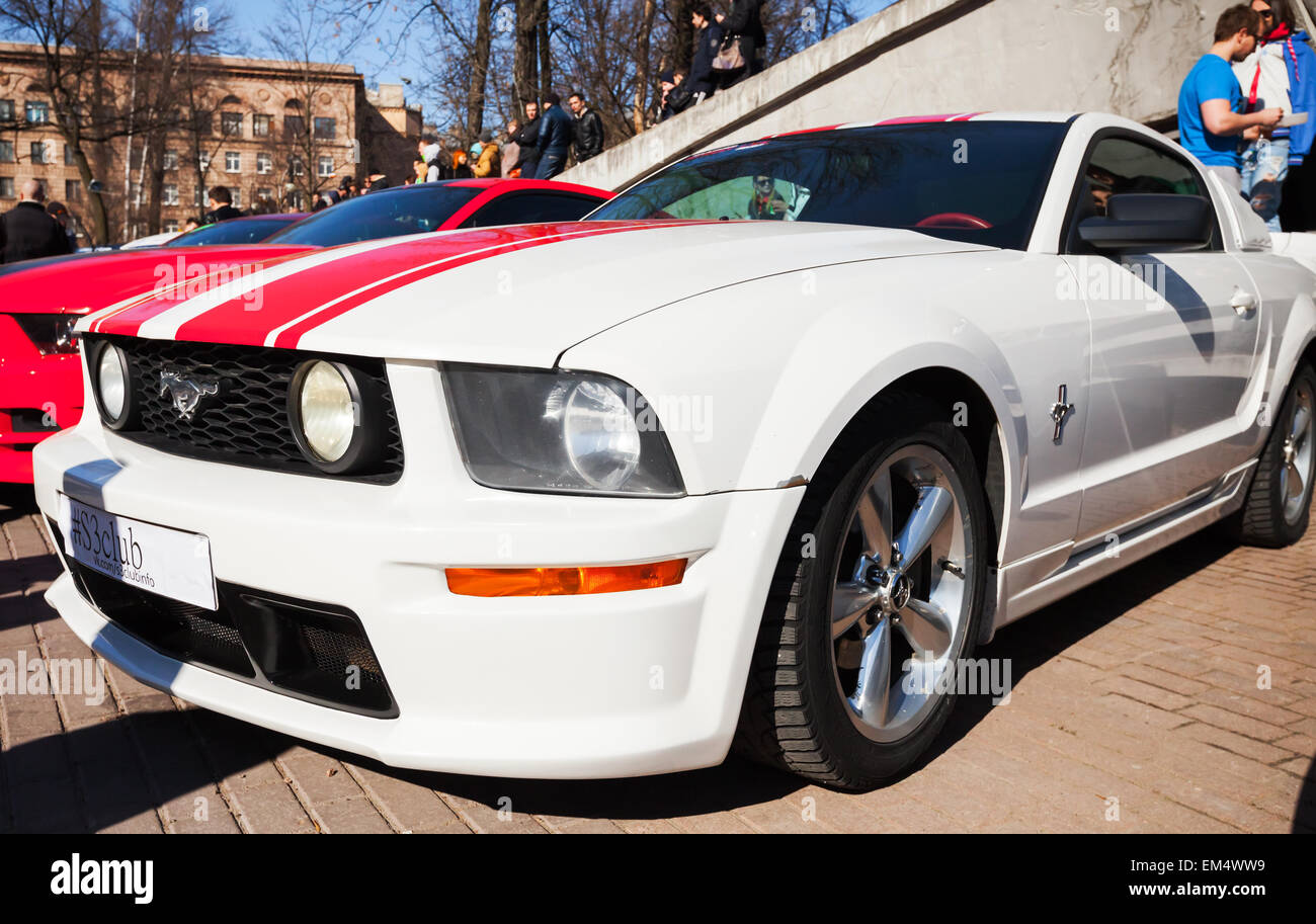 San Pietroburgo, Russia - 11 Aprile 2015: Bianco Ford Mustang con strisce rosse si erge parcheggiato sulla strada di città Foto Stock
