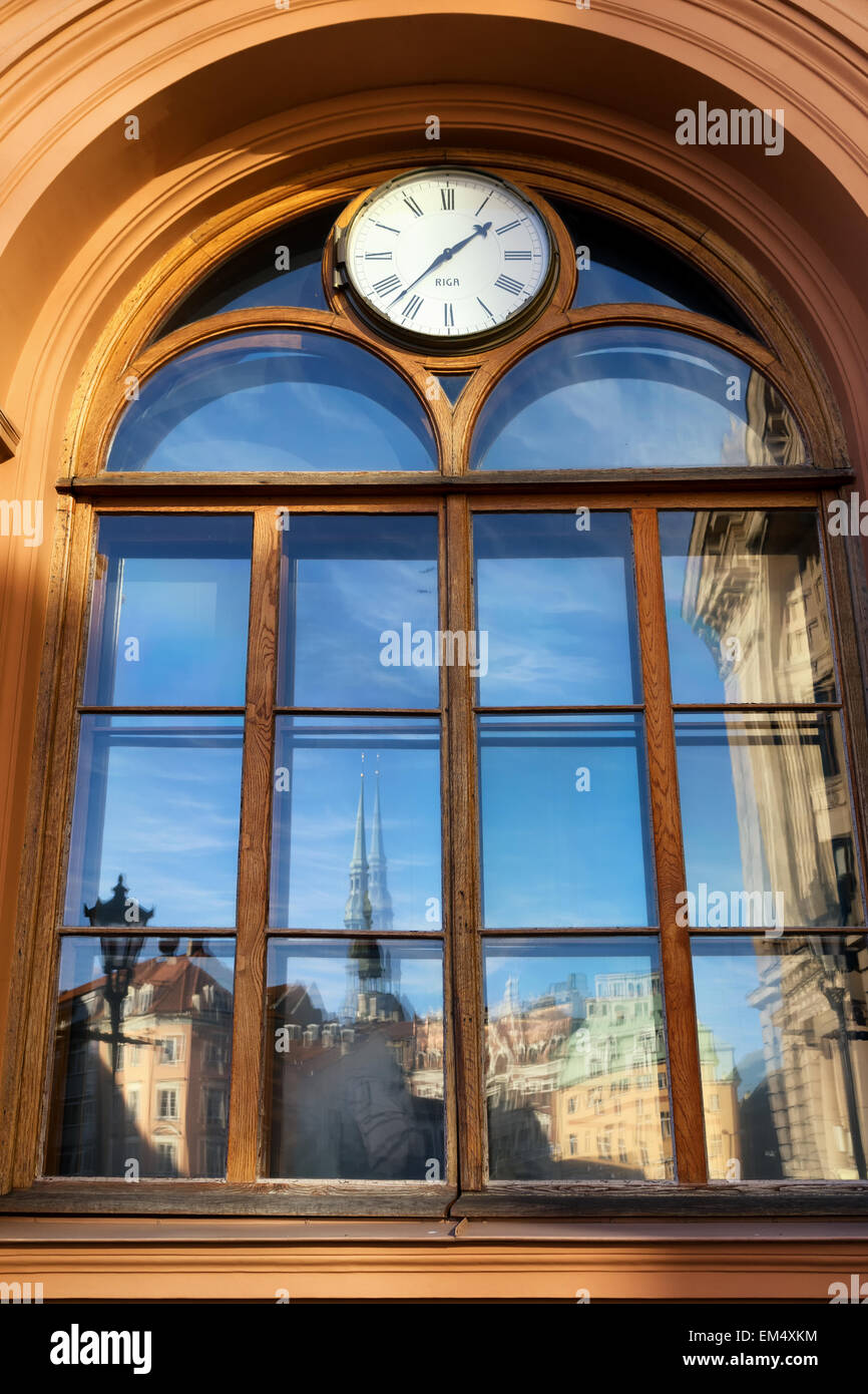 La riflessione della città vecchia in piazza Duomo a Riga in un edificio con un orologio sullo scambio. Riga. Lettonia Foto Stock