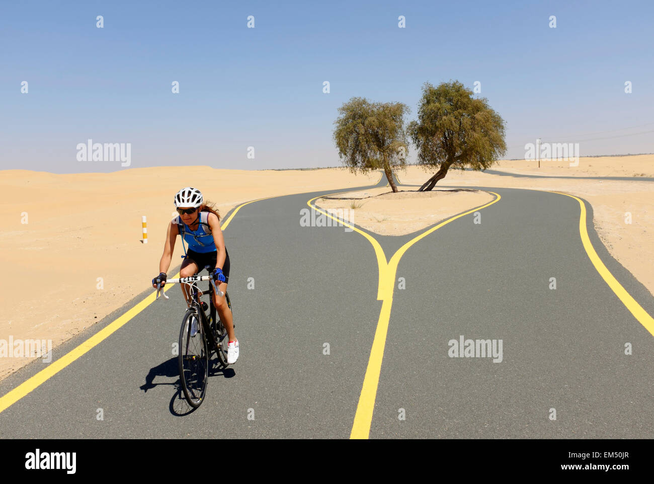 Ciclista femmina del nuovo ciclo del deserto via Al Qudra in Dubai Emirati Arabi Uniti Foto Stock