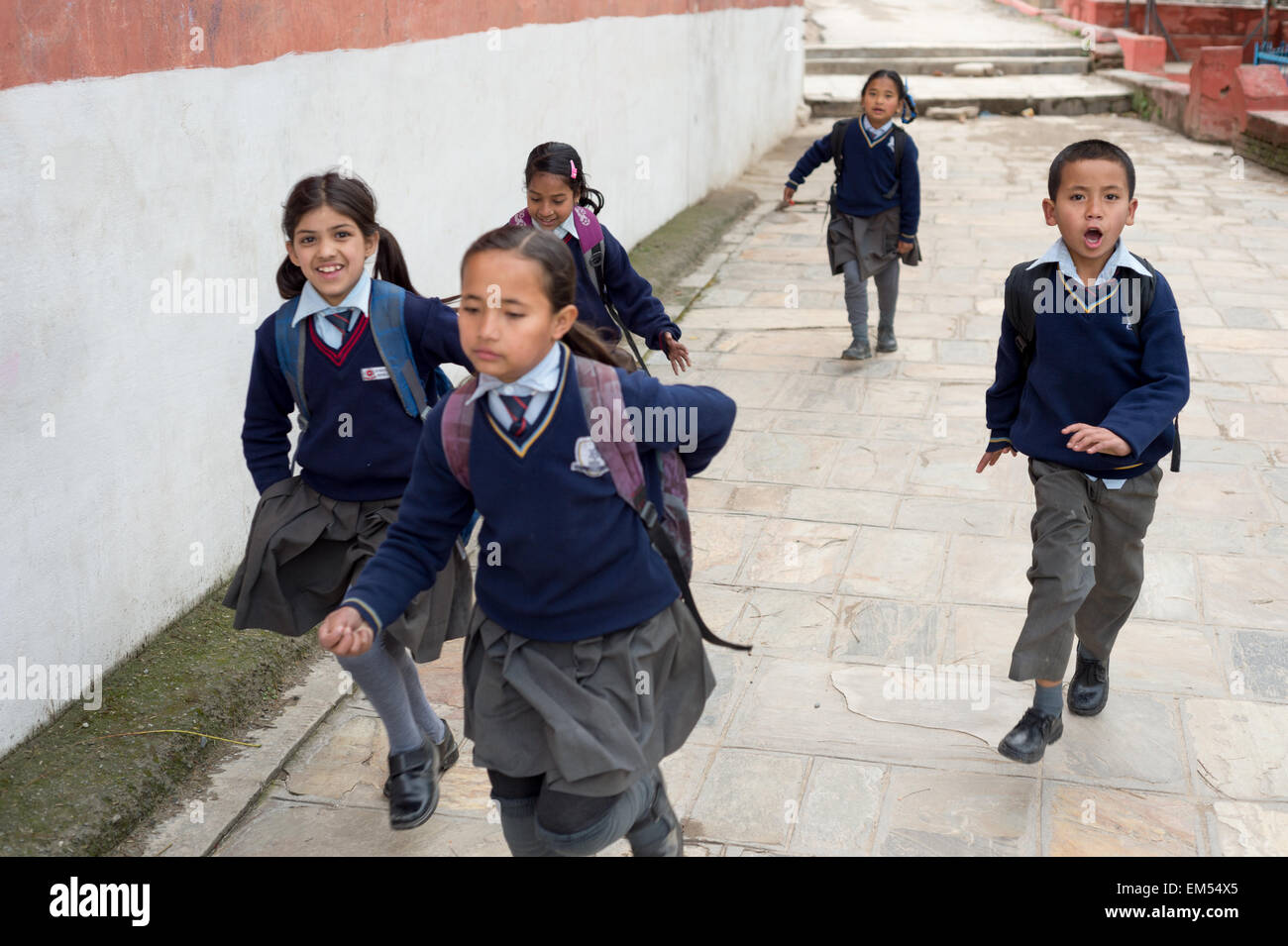 Un gruppo di bambini running back home dopo la scuola Foto Stock