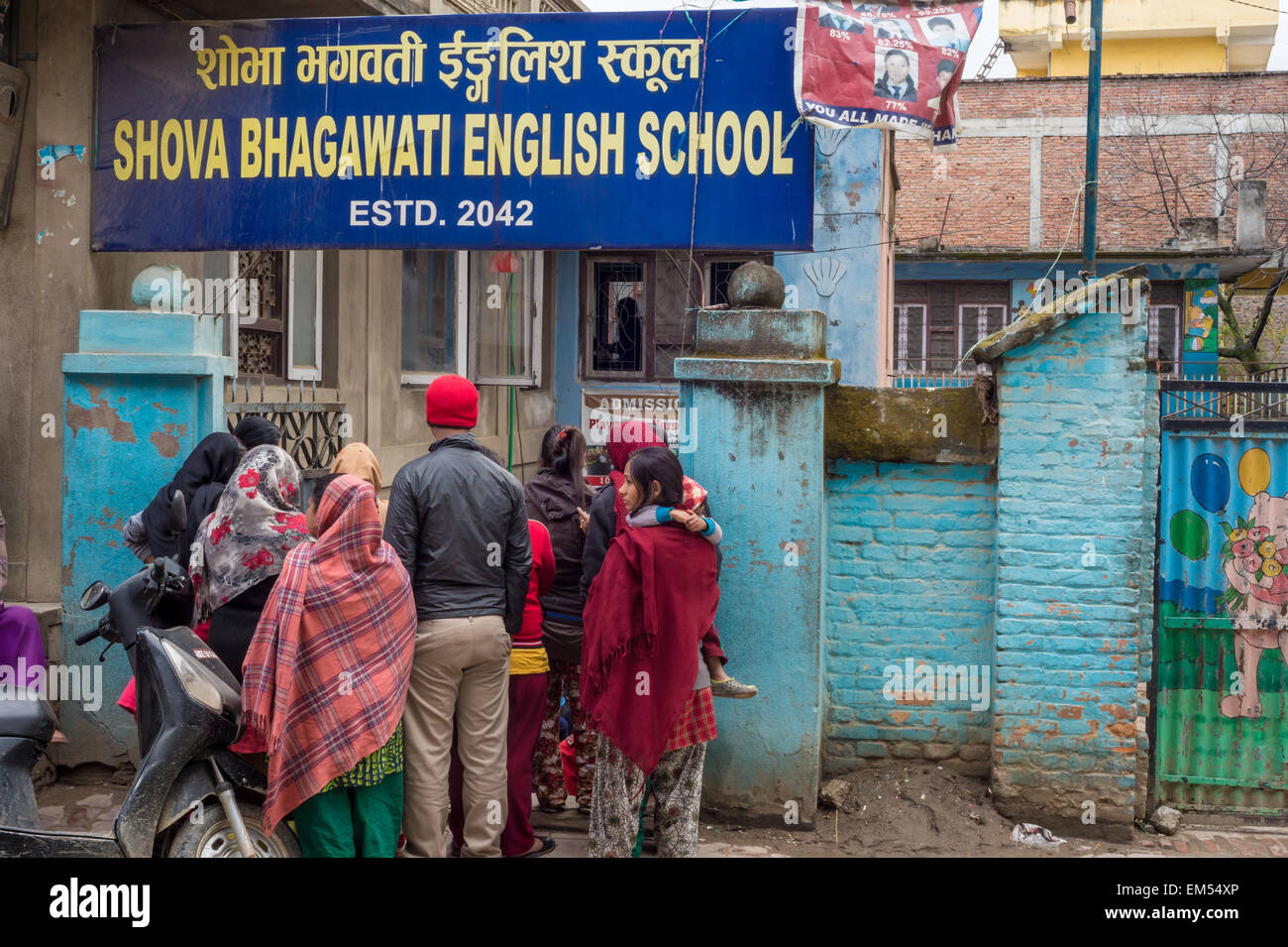 Kathmandu, Nepal - 3 marzo 2015: i genitori in attesa per i loro bambini al di fuori di un shova bhagawati Scuola di inglese Foto Stock