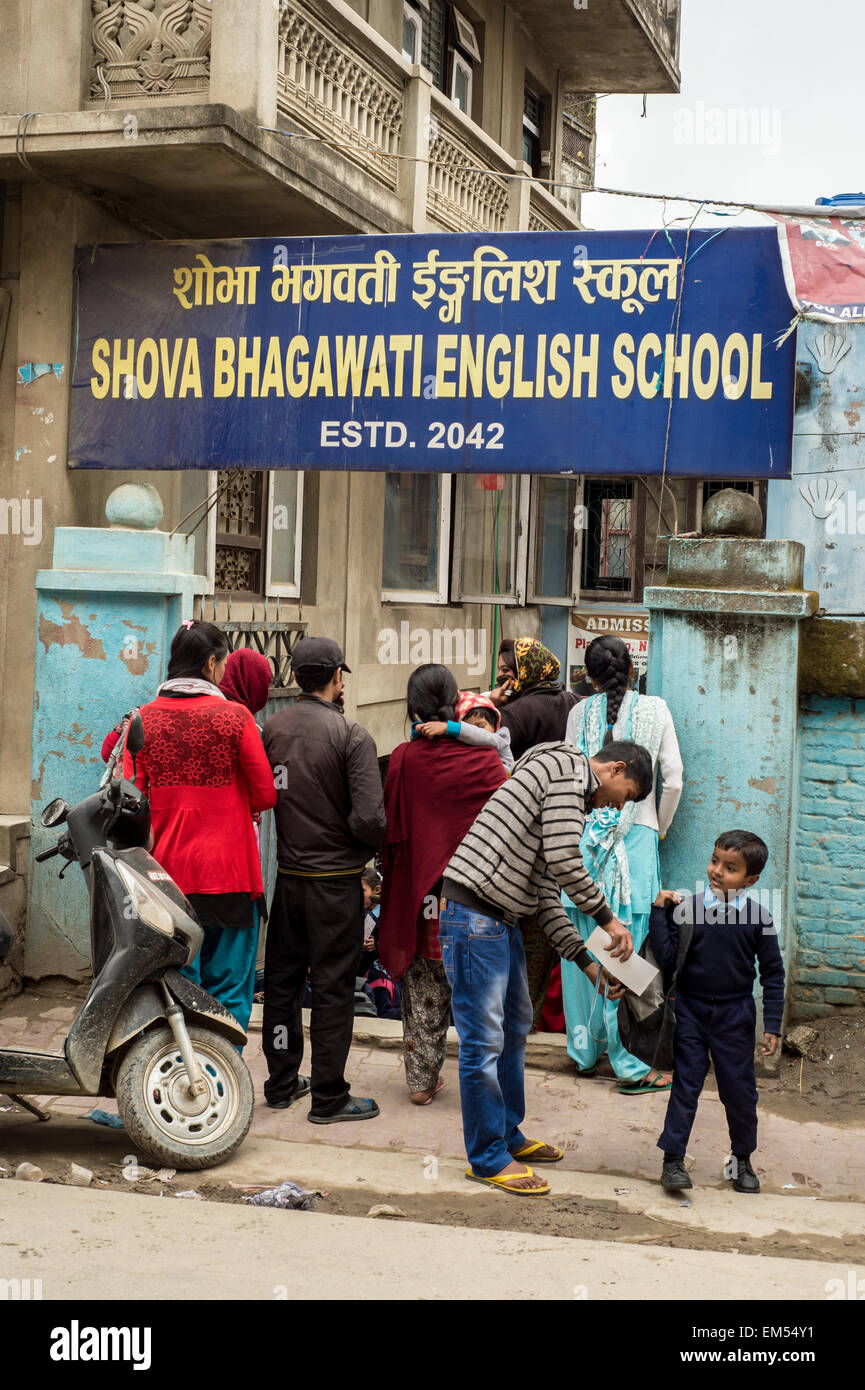 Kathmandu, Nepal - 3 marzo 2015: i genitori in attesa per i loro bambini al di fuori di un shova bhagawati Scuola di inglese Foto Stock