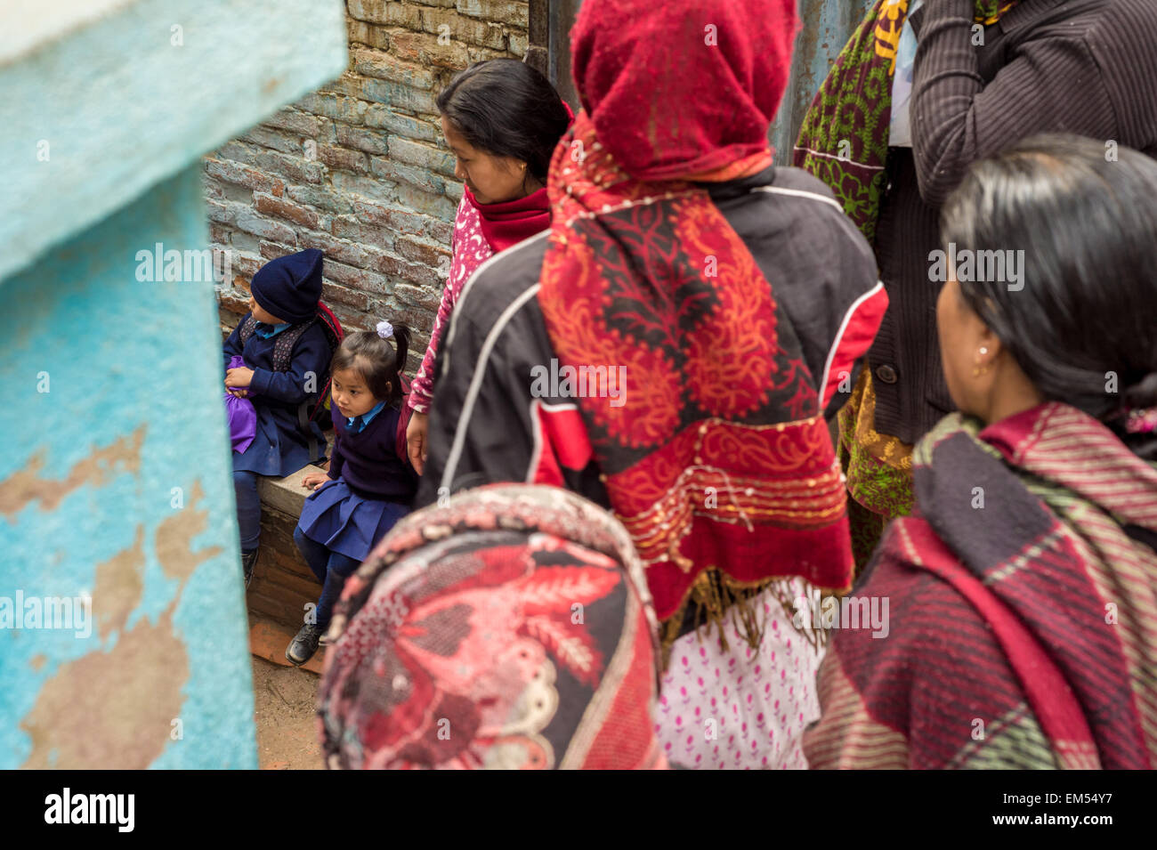 In attesa dei genitori per i loro figli al di fuori di una scuola nepalese Foto Stock