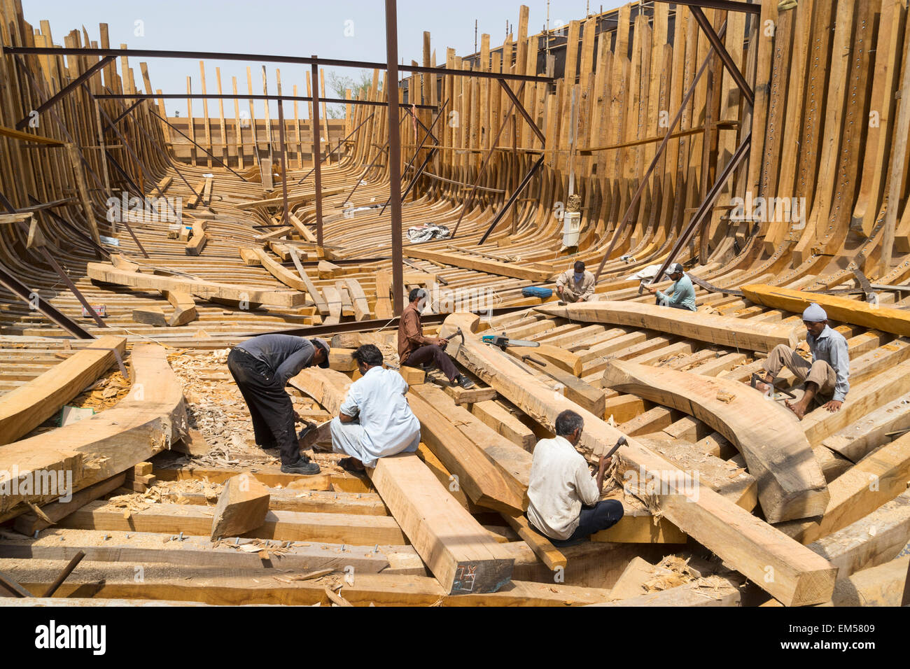 Gli artigiani la costruzione di un tradizionale dhow di legno nave cargo in cantiere accanto al fiume Creek di Dubai Emirati Arabi Uniti Foto Stock