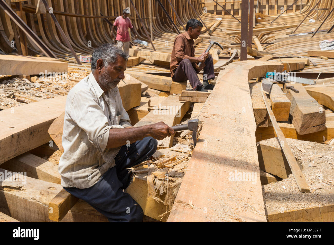 Gli artigiani la costruzione di un tradizionale dhow di legno nave cargo in cantiere accanto al fiume Creek di Dubai Emirati Arabi Uniti Foto Stock