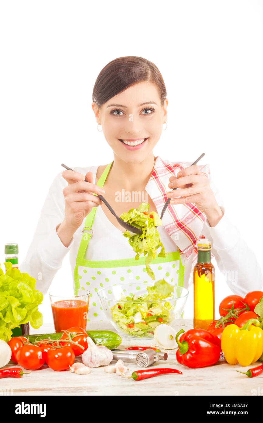 Giovane donna la preparazione di insalata. Cibo sano e concetto di dieta. Isolato su bianco. Foto Stock