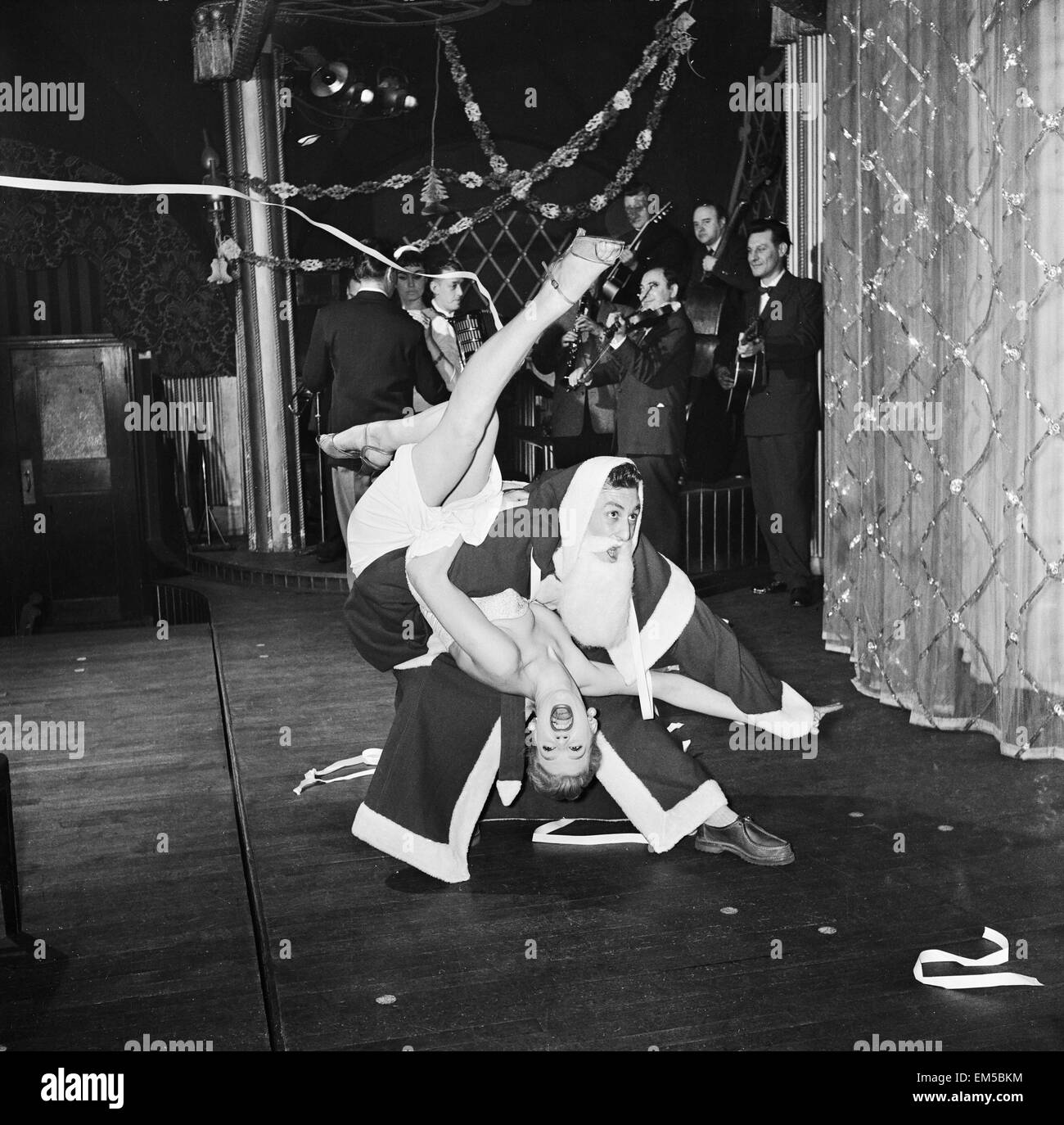 Rock n Roll Santa (Roger Palmer) trattiene il piano con Pamela Bevan a Londra, Pigalle Club. Il 22 dicembre 1956. Foto Stock