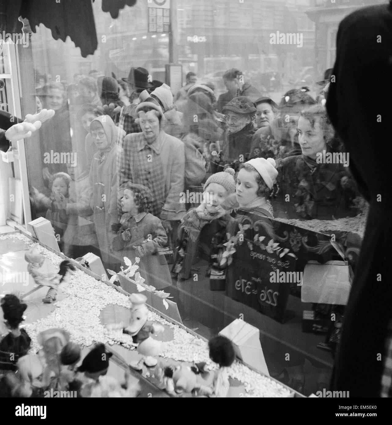 Le donne e i bambini guardando attraverso Sefridge negozio finestra su Oxford Street, Londra, la settimana prima di Natale. 19 dicembre 1955. Foto Stock
