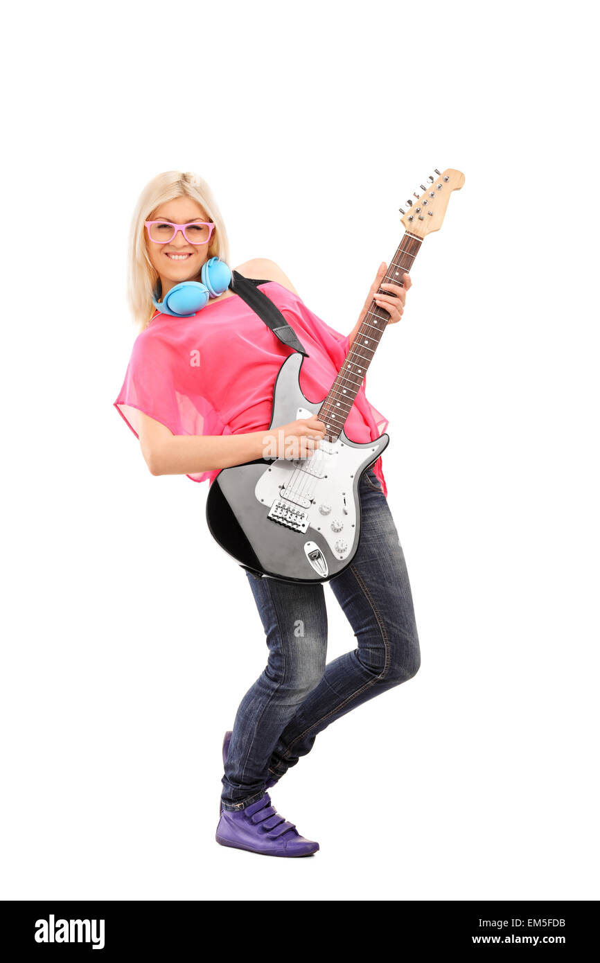 A piena lunghezza Ritratto di una bella donna bionda suonando una chitarra elettrica e indossa le cuffie blu intorno al collo Foto Stock