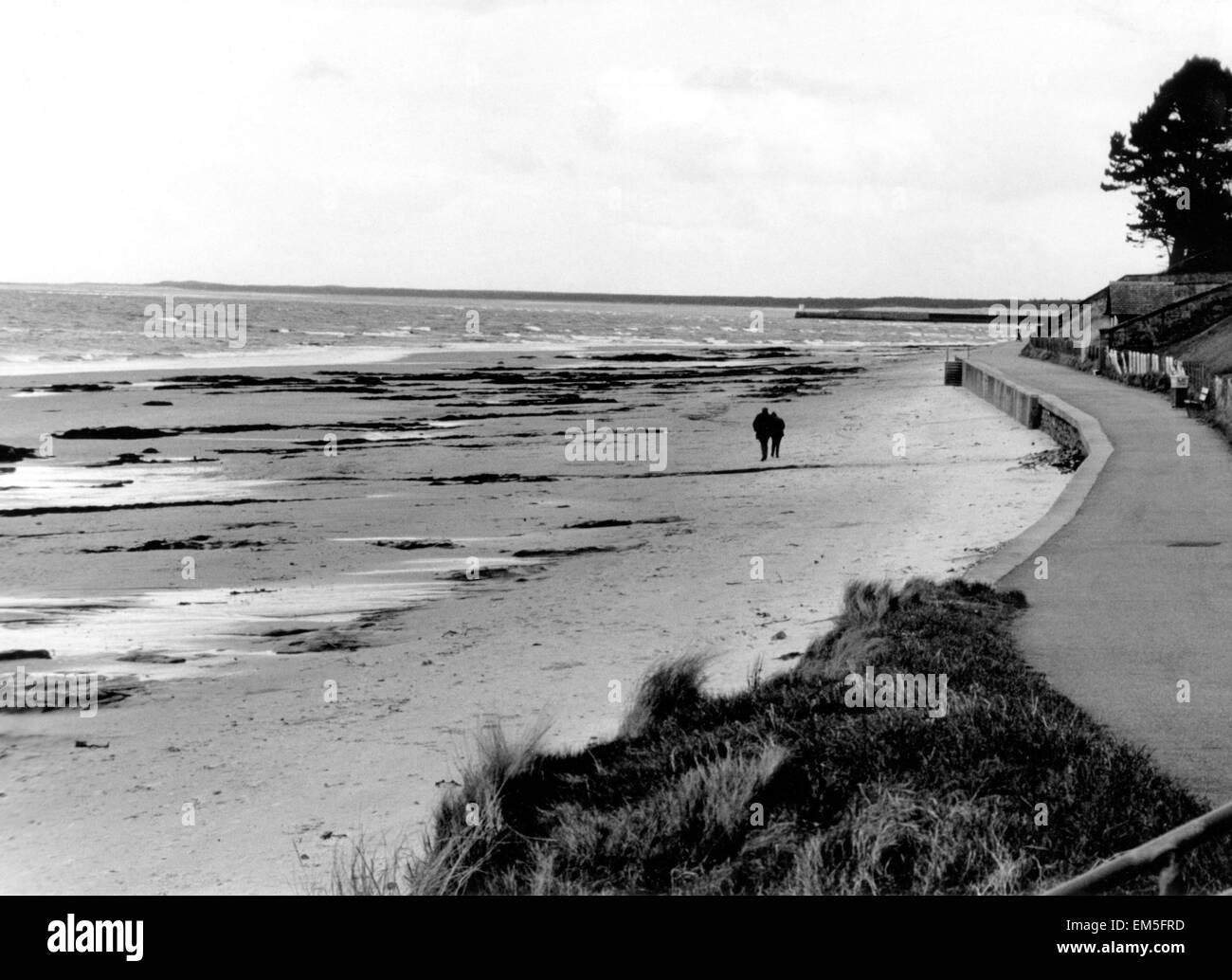 Un paio di fare una passeggiata lungo Nairn Beach in Scozia. Circa 1970. Foto Stock