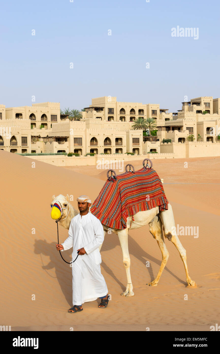 Uomo arabo con cammello Al Qasr al Sarab Hotel da Anantara in Empty Quarter di Abu Dhabi Emirati Arabi Uniti Foto Stock