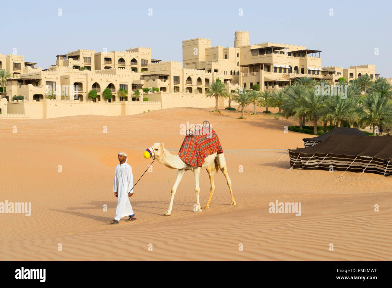 Uomo arabo con cammello Al Qasr al Sarab Hotel da Anantara in Empty Quarter di Abu Dhabi Emirati Arabi Uniti Foto Stock