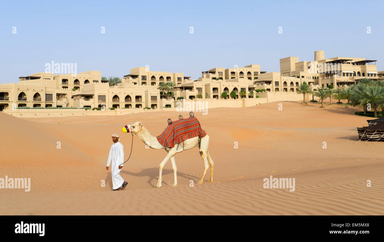 Uomo arabo con cammello Al Qasr al Sarab Hotel da Anantara in Empty Quarter di Abu Dhabi Emirati Arabi Uniti Foto Stock