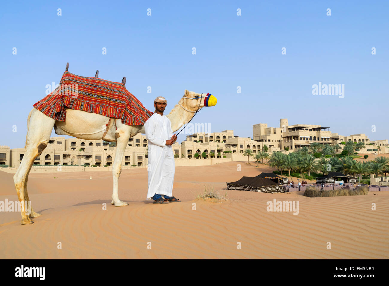 Uomo arabo con cammello Al Qasr al Sarab Hotel da Anantara in Empty Quarter di Abu Dhabi Emirati Arabi Uniti Foto Stock