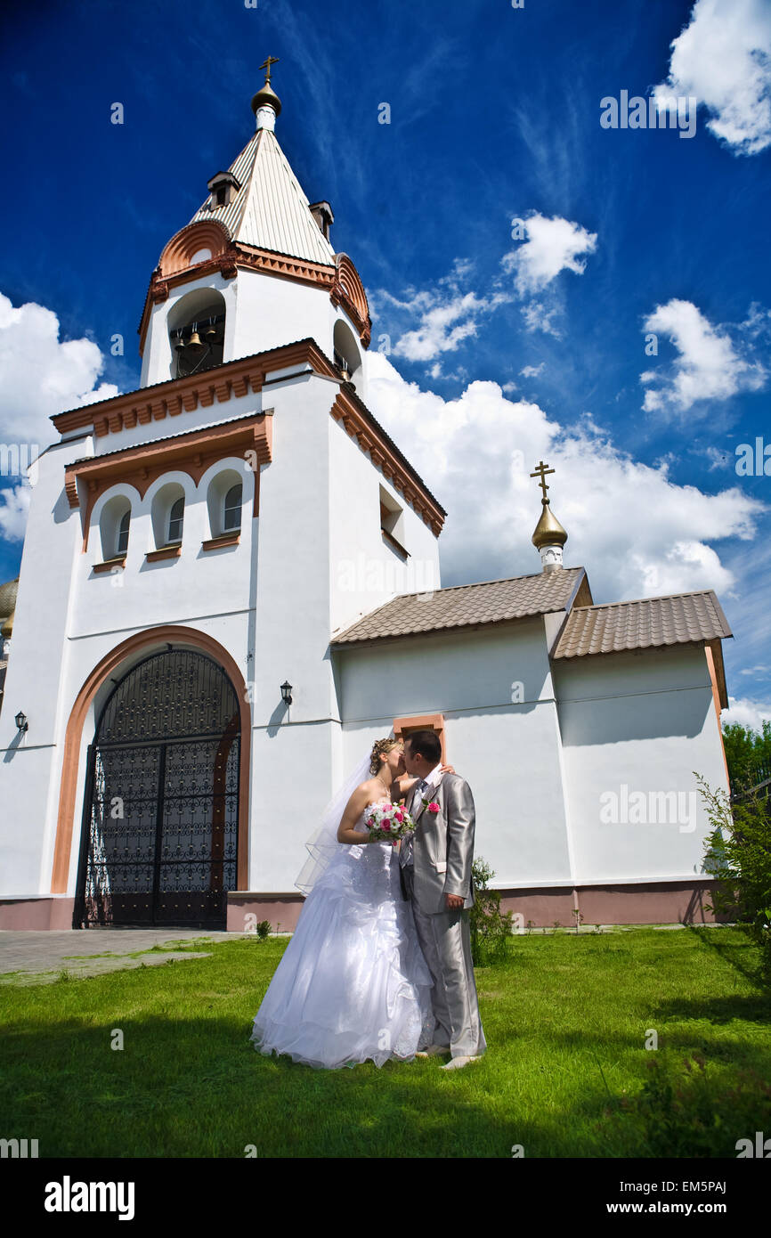 Nuovo bacio sposato su uno sfondo di chiesa Foto Stock