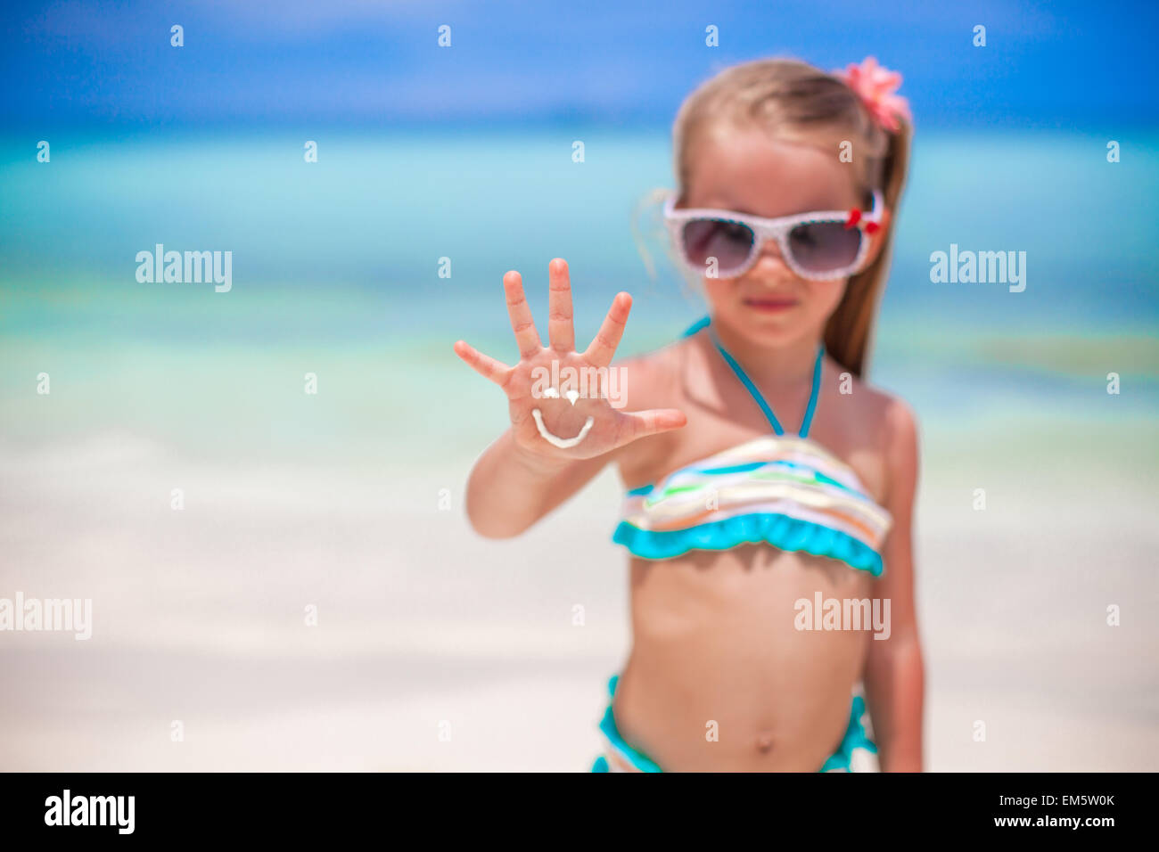 Close-up di sorriso realizzato da Sun crema sulla mano della ragazza Foto Stock