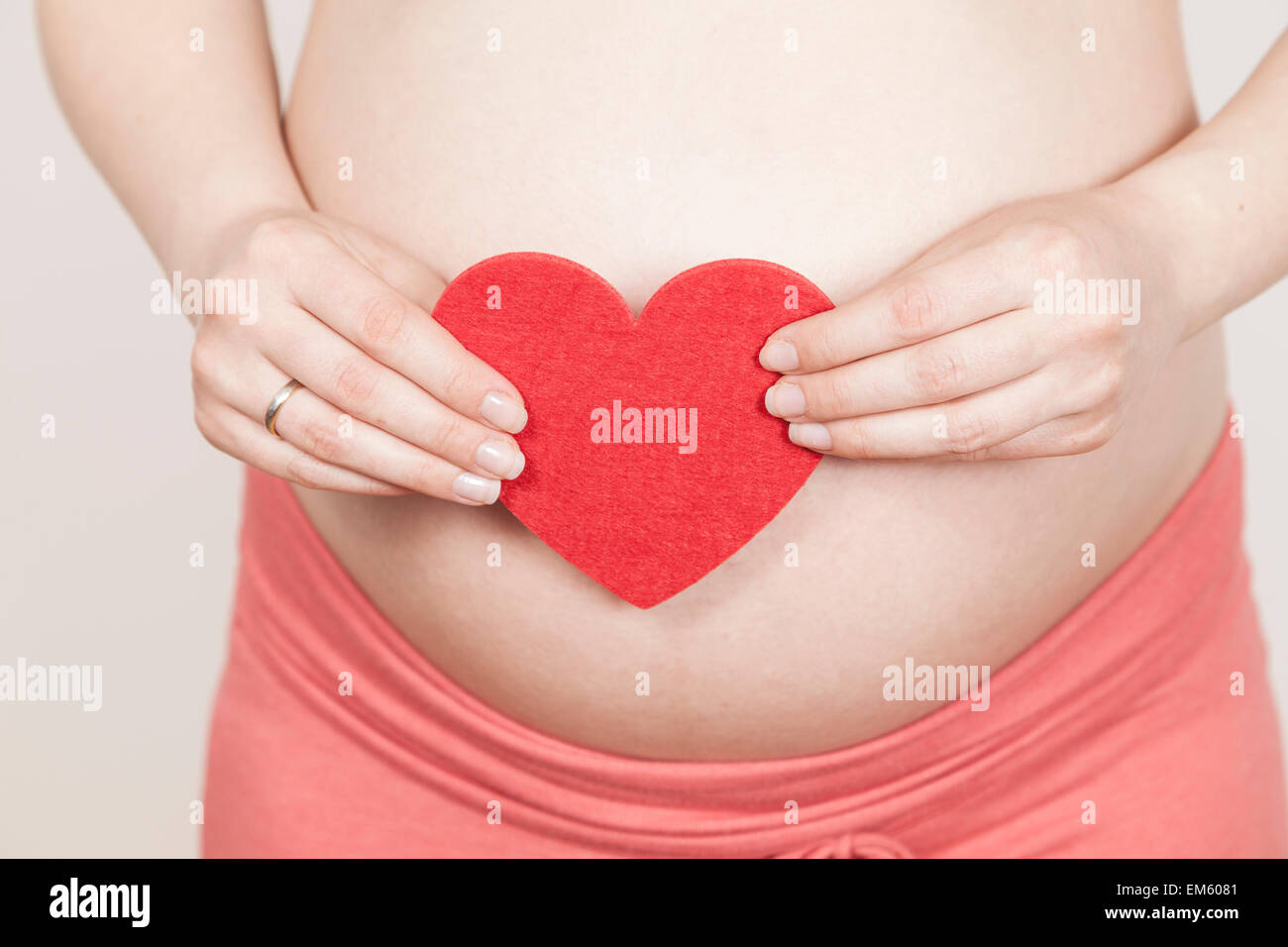 Madre Expection holding cuore rosso Foto Stock