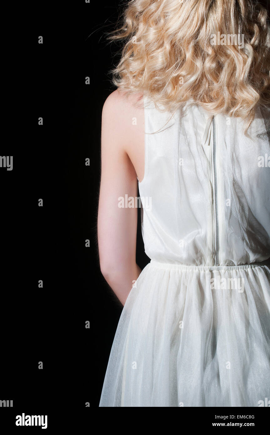 Vista posteriore di una giovane donna in abito bianco Foto Stock