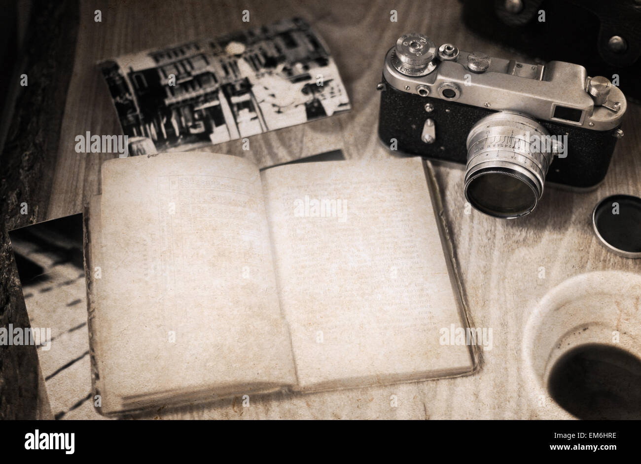 Le opere in stile retrò, vecchia fotocamera, libro aperto, vuoto tazza di caffè Foto Stock