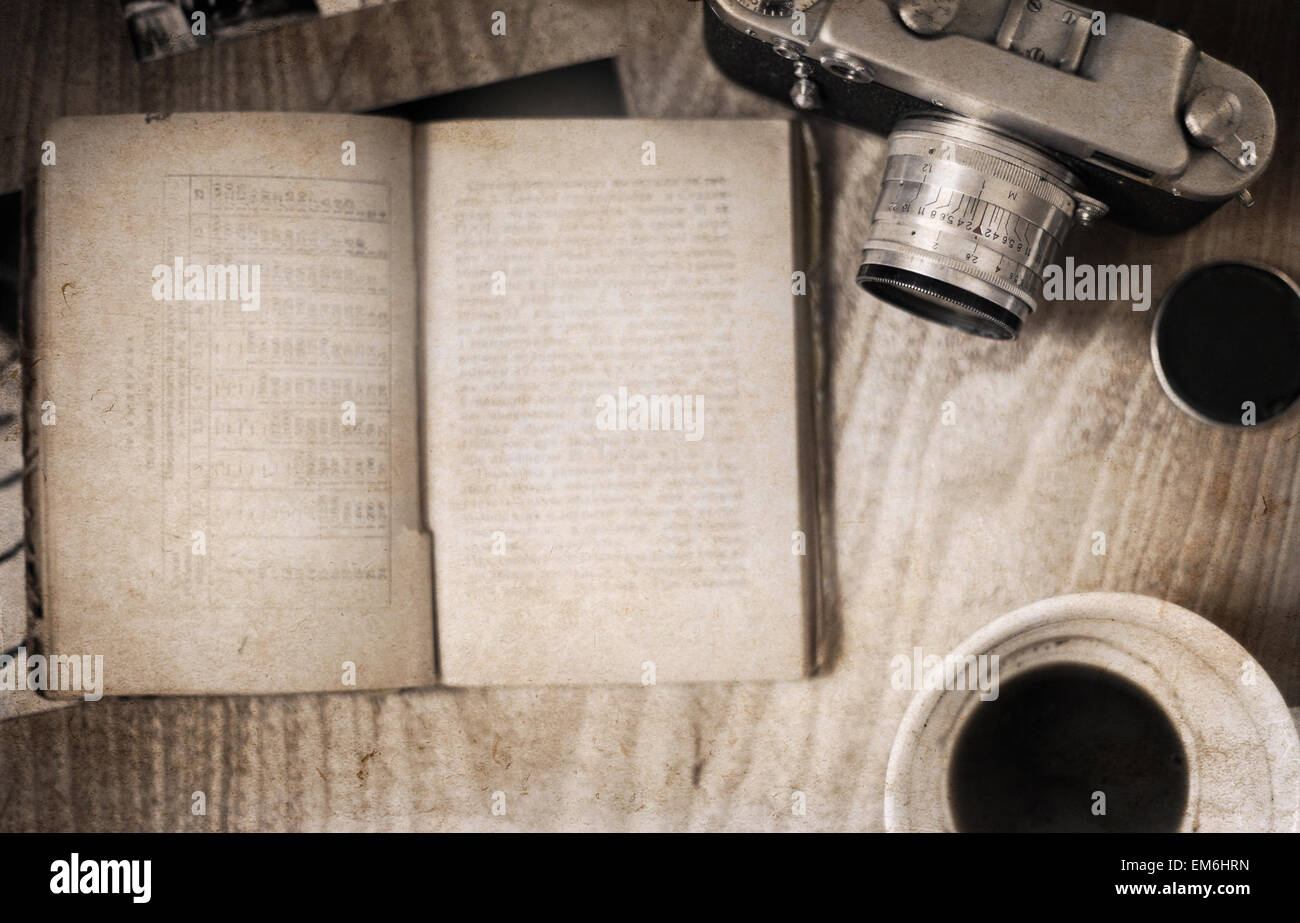 Le opere in stile retrò, vecchia fotocamera, libro aperto, vuoto tazza di caffè Foto Stock