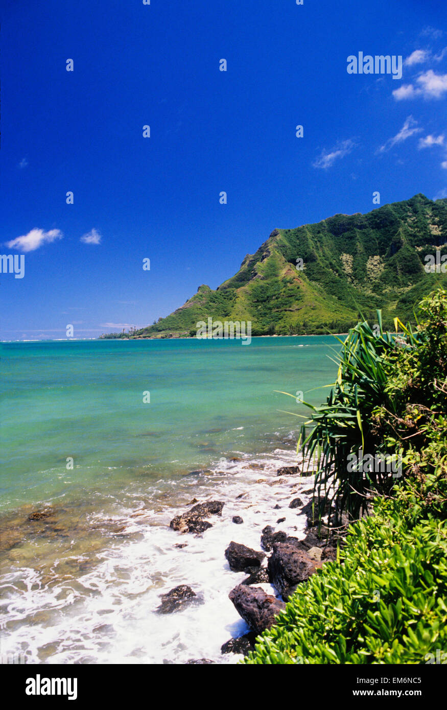Stati Uniti d'America, Hawaii, Oahu, blu turchese litorale con lussureggianti montagne in distanza; Kahana Bay Foto Stock