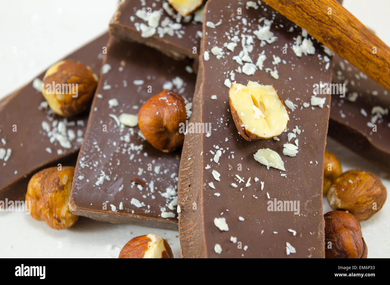 Cioccolato fondente nocciole e cannella su bianco Foto Stock