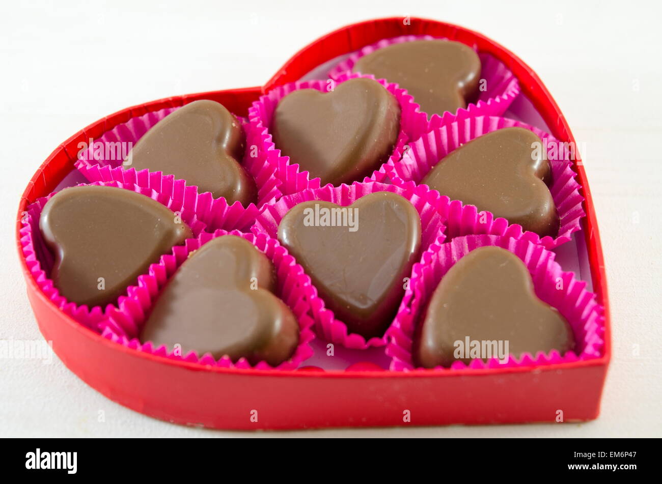 Deliziosamente guardando al cioccolato a forma di cuore in un cuore rosso scatola sagomata Foto Stock