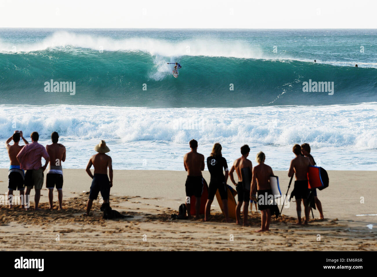 Hawaii, Oahu, North Shore, Pipeline, spettatori Guarda Surfer da riva. Foto Stock