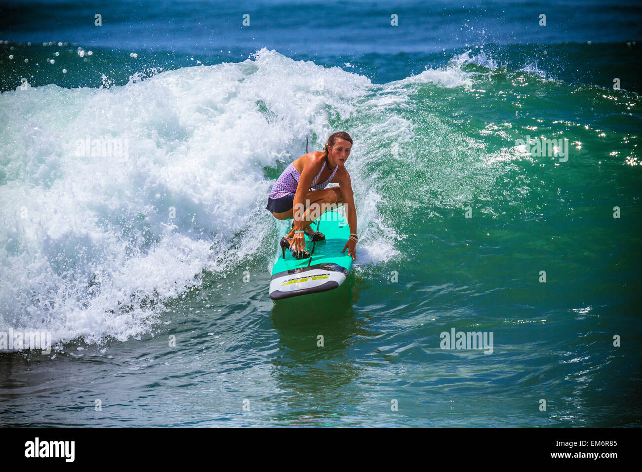 Surfer Girl le catture in onda tacchi alti. Foto Stock