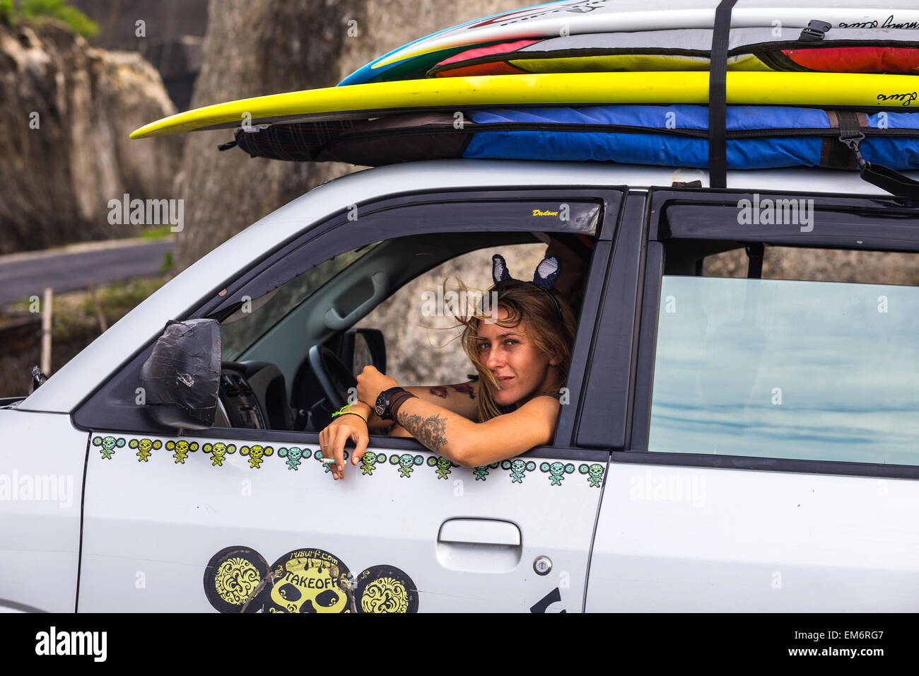 Ragazza seduta in auto con la tavola da surf. Foto Stock