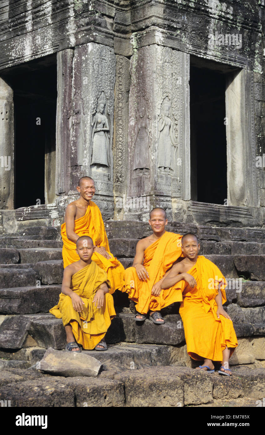 Cambogia Siem Reap, Agnkor Thom, tempio Bayon con quattro monaci seduti sulle scale Foto Stock