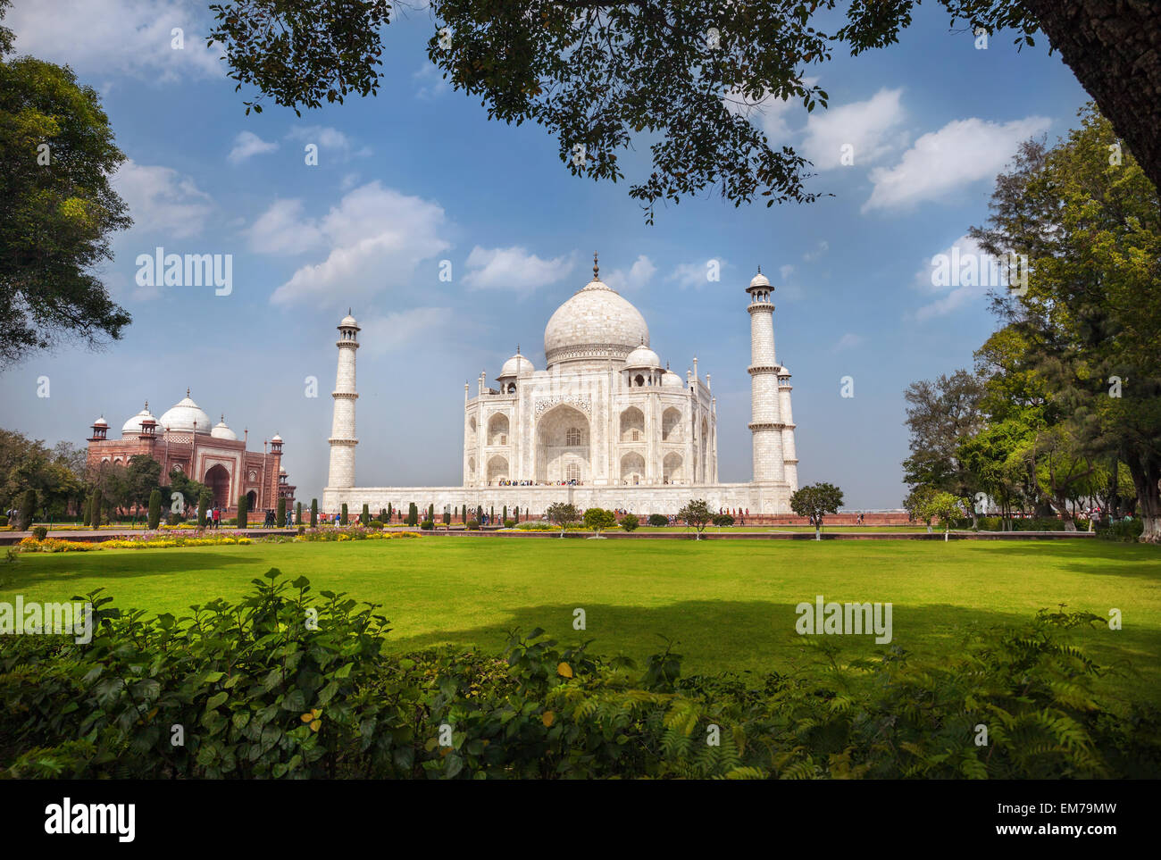 Taj Mahal tomba e di erba verde al blu cielo nuvoloso in Agra, Uttar Pradesh, India Foto Stock
