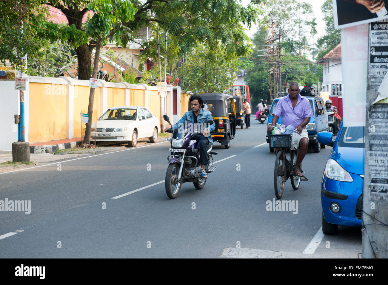 Persone a cavallo e bici motrocycles attraverso Fort Kochi, Kerala India Foto Stock