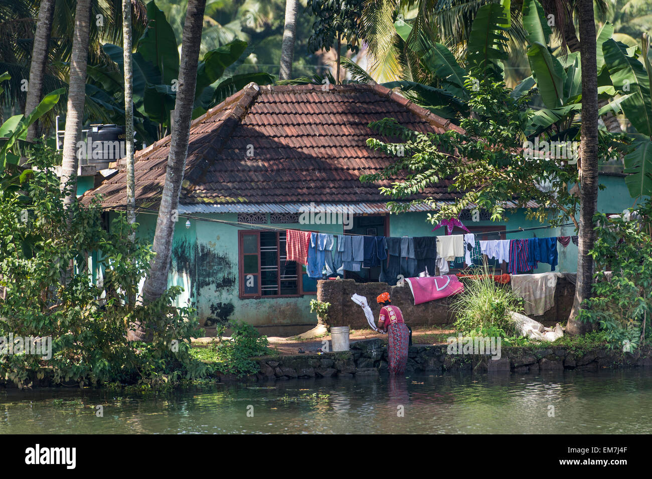 La donna il lavaggio della biancheria in un canale, il sistema di canale di lagune, Champakulam, Kerala, India Foto Stock
