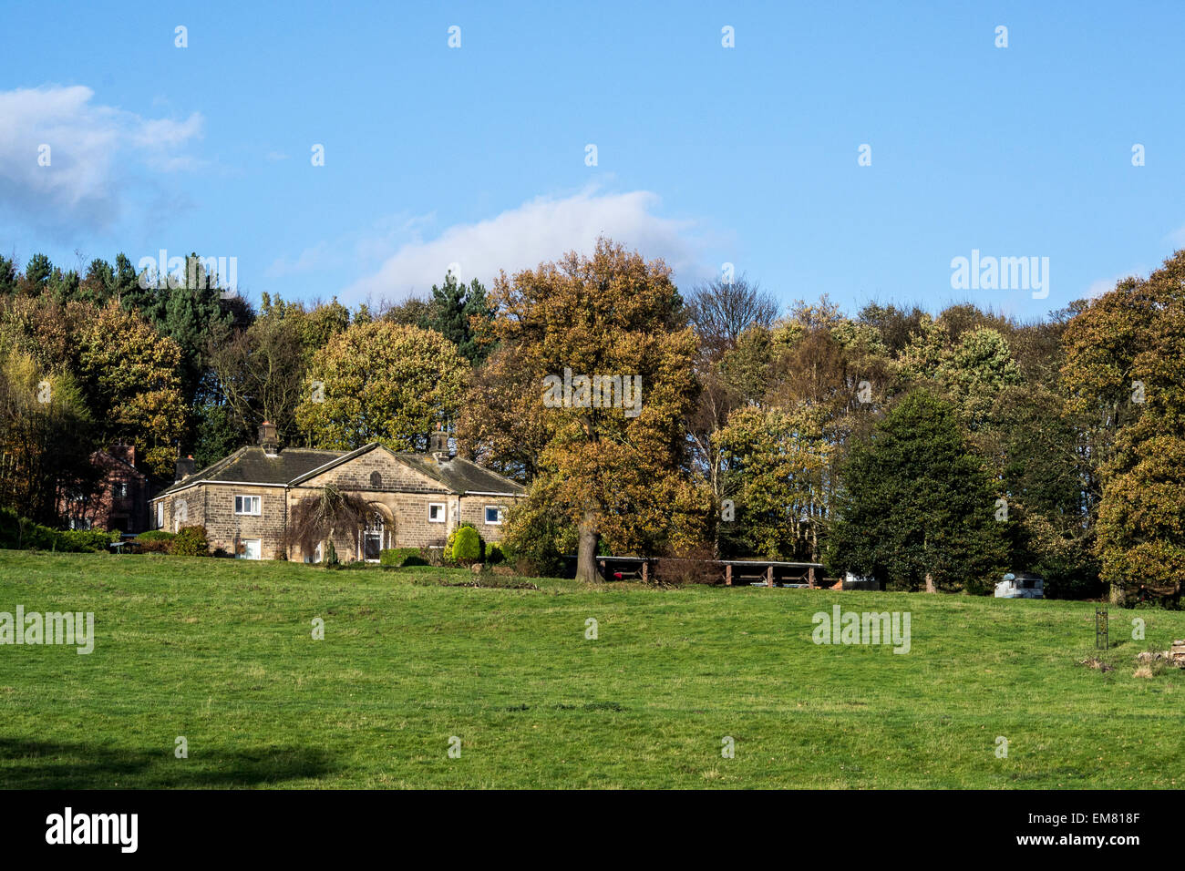 Paesaggio di un casolare di campagna accanto ad alberi e un campo Foto Stock