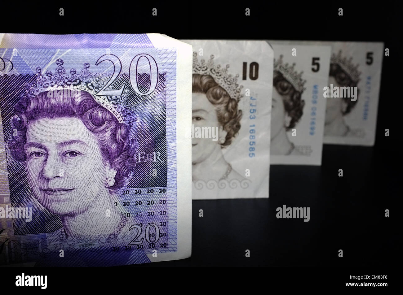 Un britannico £20, £10 e due £5 note fotografati contro uno sfondo nero. Foto Stock