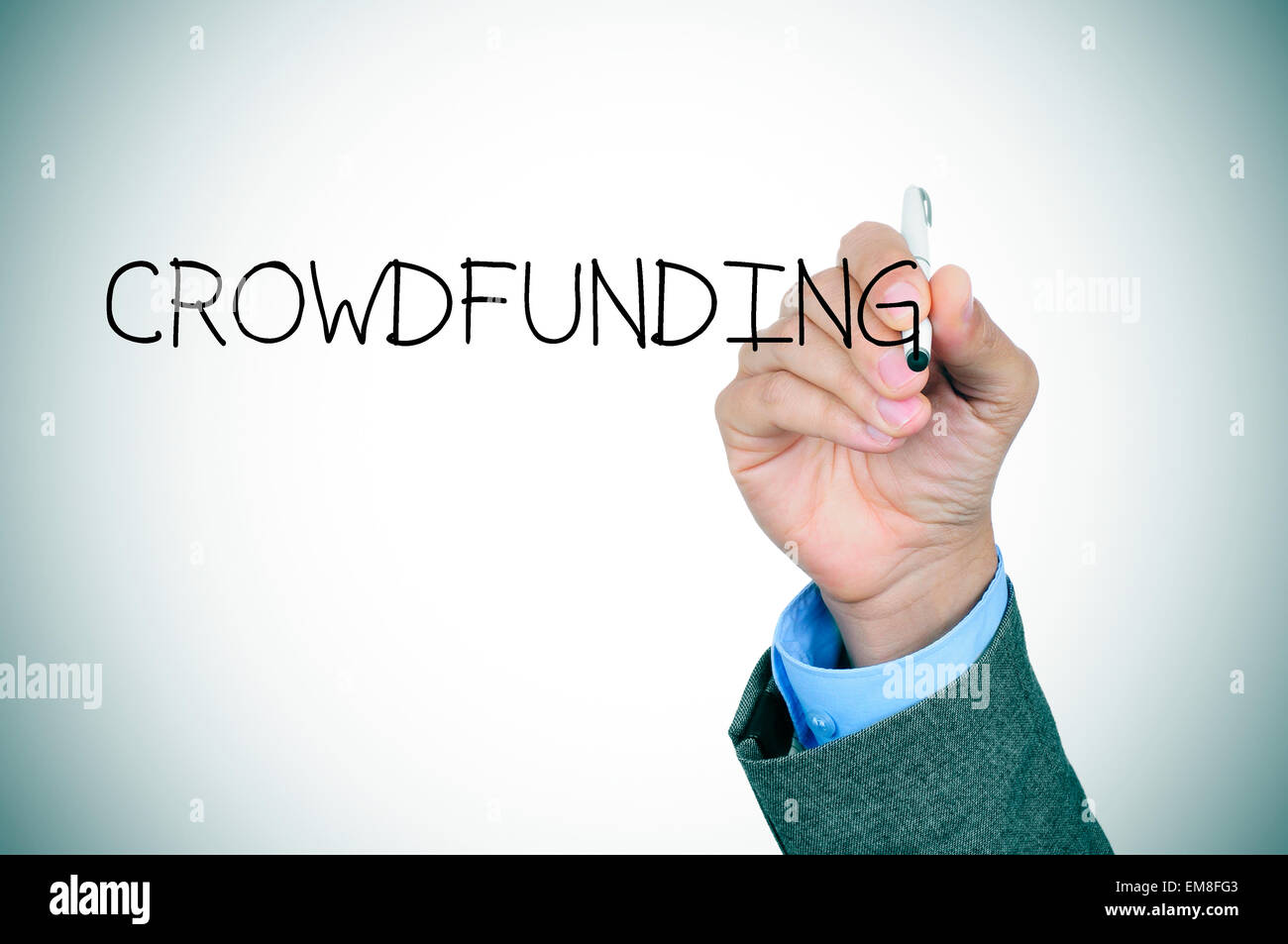 Primo piano della mano di un giovane uomo caucasico in un abito grigio a scrivere la parola crowdfunding in primo piano, lievi vignette aggiungi Foto Stock