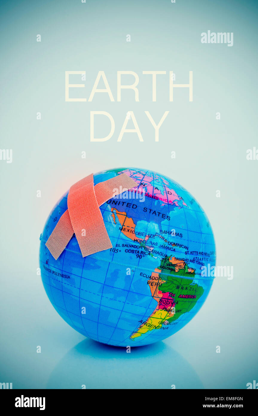 Due cerotti adesivi formano una croce su un globo terrestre e il testo per la giornata della terra Foto Stock
