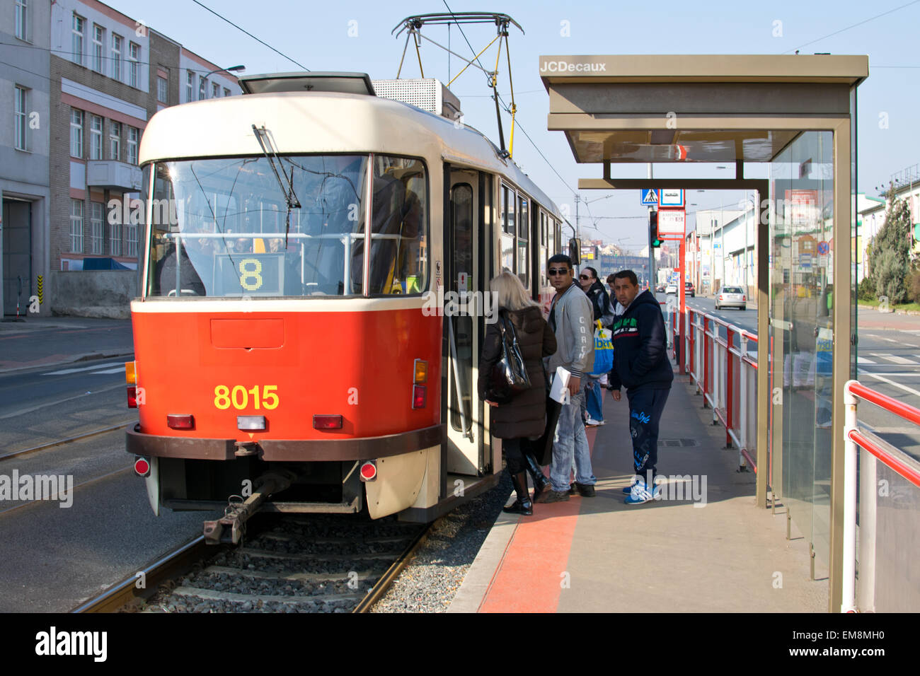 I pedoni a salire su un tram da un rifugio di sicurezza a Praga Foto Stock