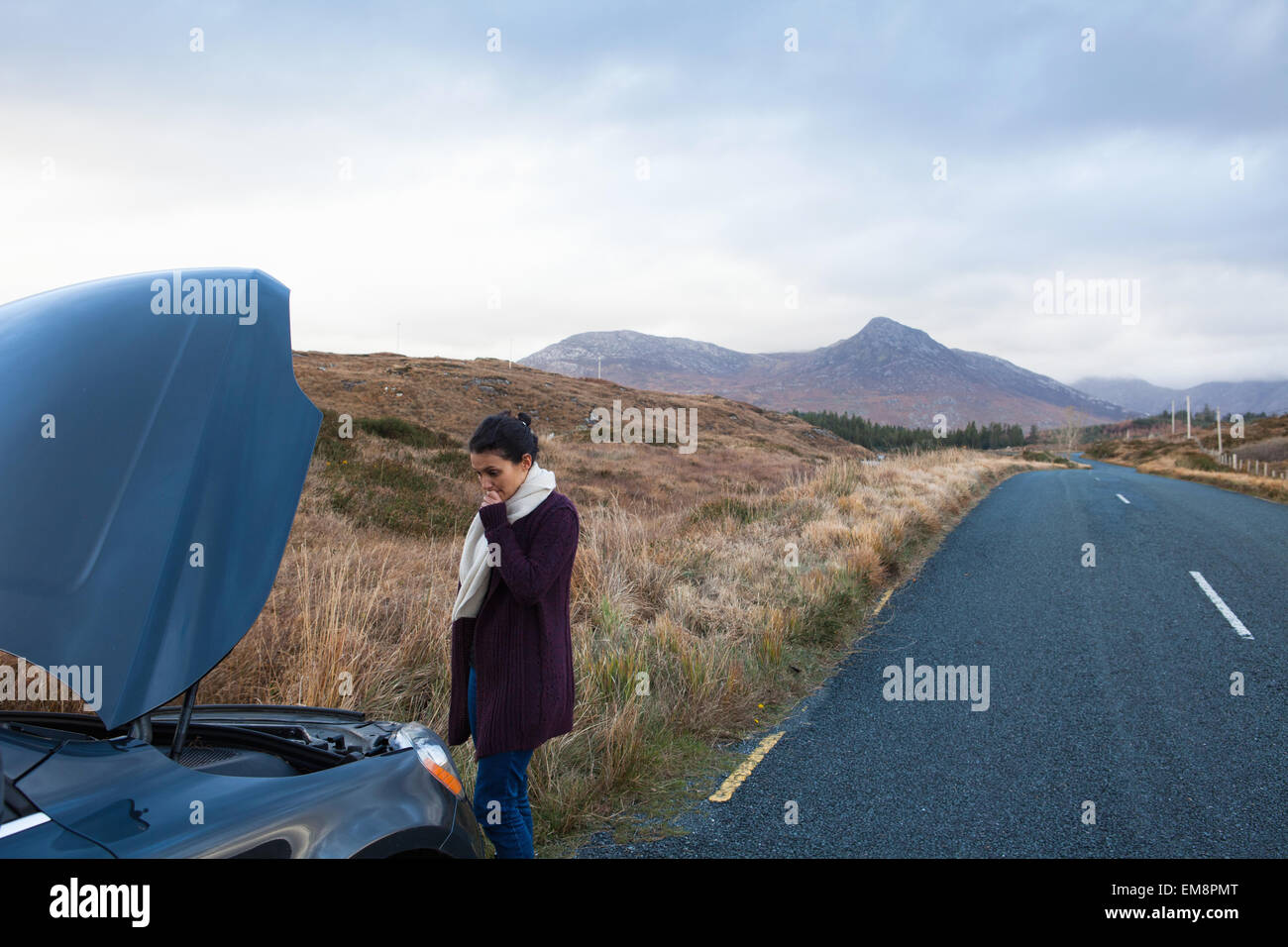Donna dal veicolo bloccato in strada, Connemara, Irlanda Foto Stock