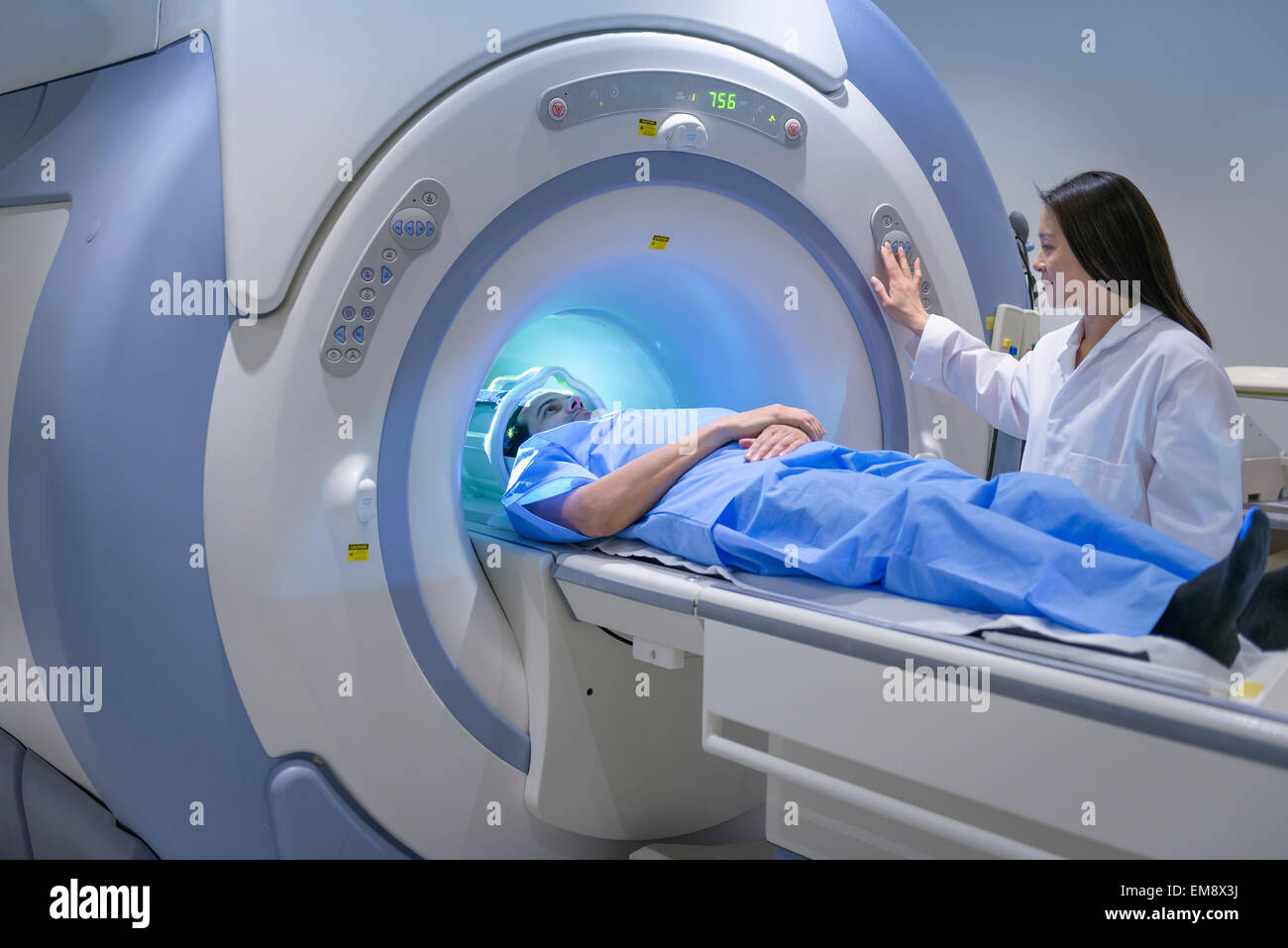 Il medico e il paziente utilizzando il rilevamento di immagini in risonanza magnetica nucleare (MRI) scanner Foto Stock
