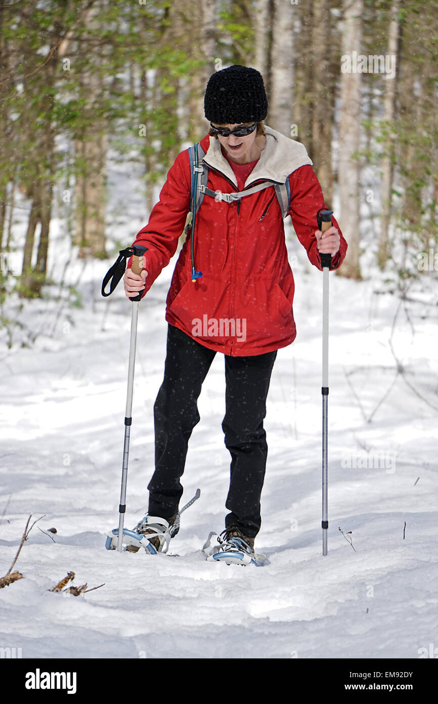 Una donna fuori per una escursione nella neve invernale con lei le racchette da neve e i poli. Foto Stock
