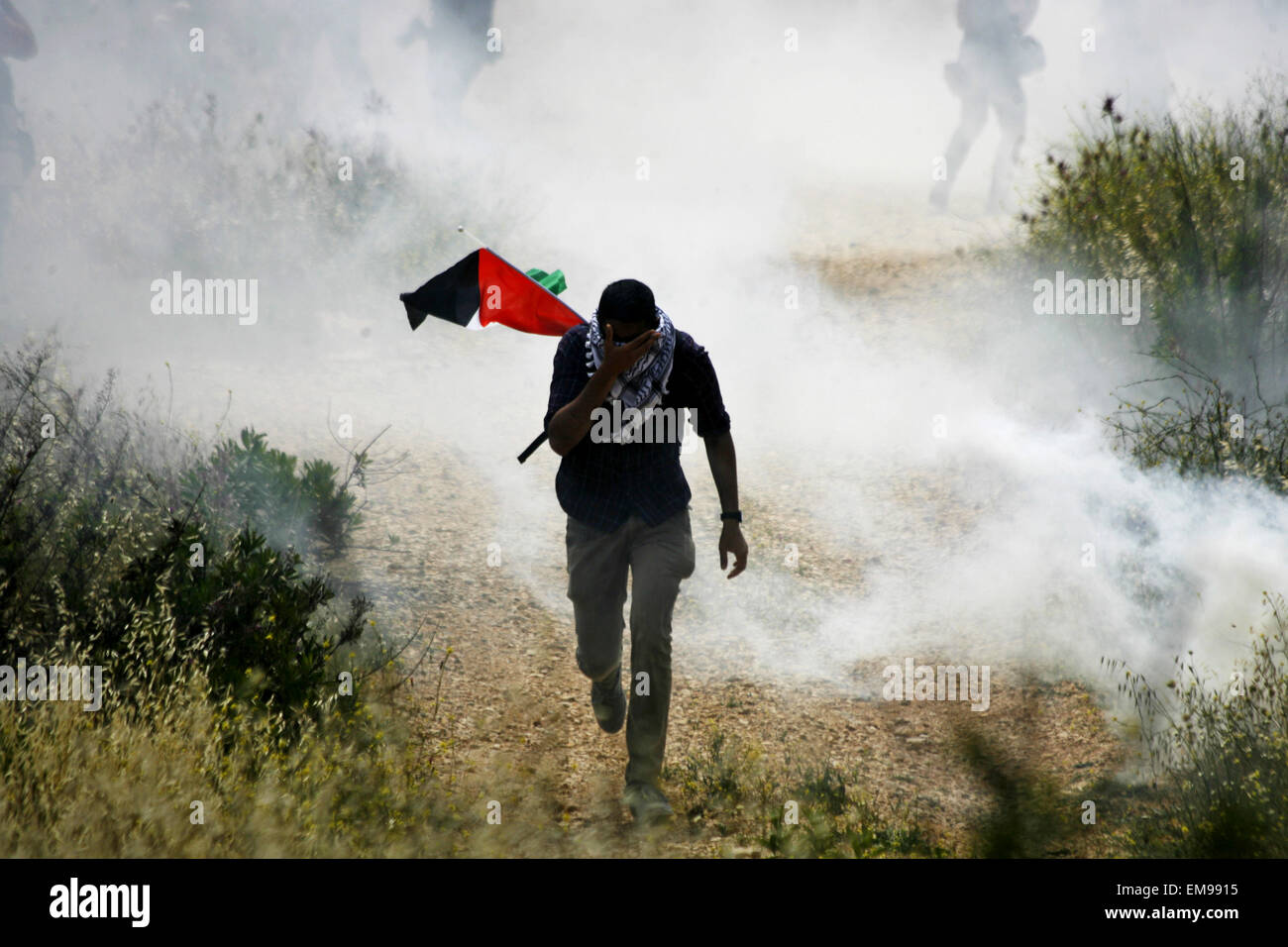 Bilin, West Bank, Territorio palestinese. Xvii Apr, 2015. Un manifestante palestinese si copre il viso da gas lacrimogeni sparati dalle forze di sicurezza israeliane durante scontri a seguito di una dimostrazione di marcatura dei prigionieri palestinesi" giorno, in Cisgiordania villaggio di Bilin, vicino a Ramallah il 17 aprile 2015. Palestinesi diritti umani gruppi dicono 6.000 prigionieri palestinesi rimangono nelle carceri israeliane e i campi di detenzione Credito: Muhesen Amren APA/images/ZUMA filo/Alamy Live News Foto Stock